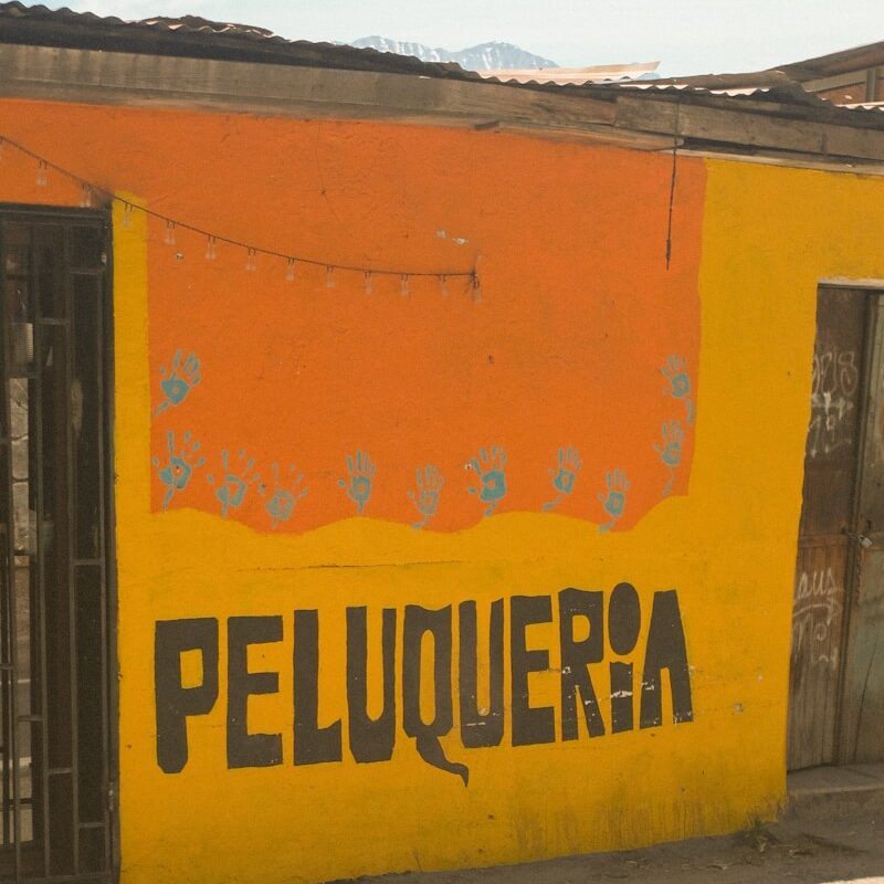 A brightly painted building with "peluqueria" sign.
